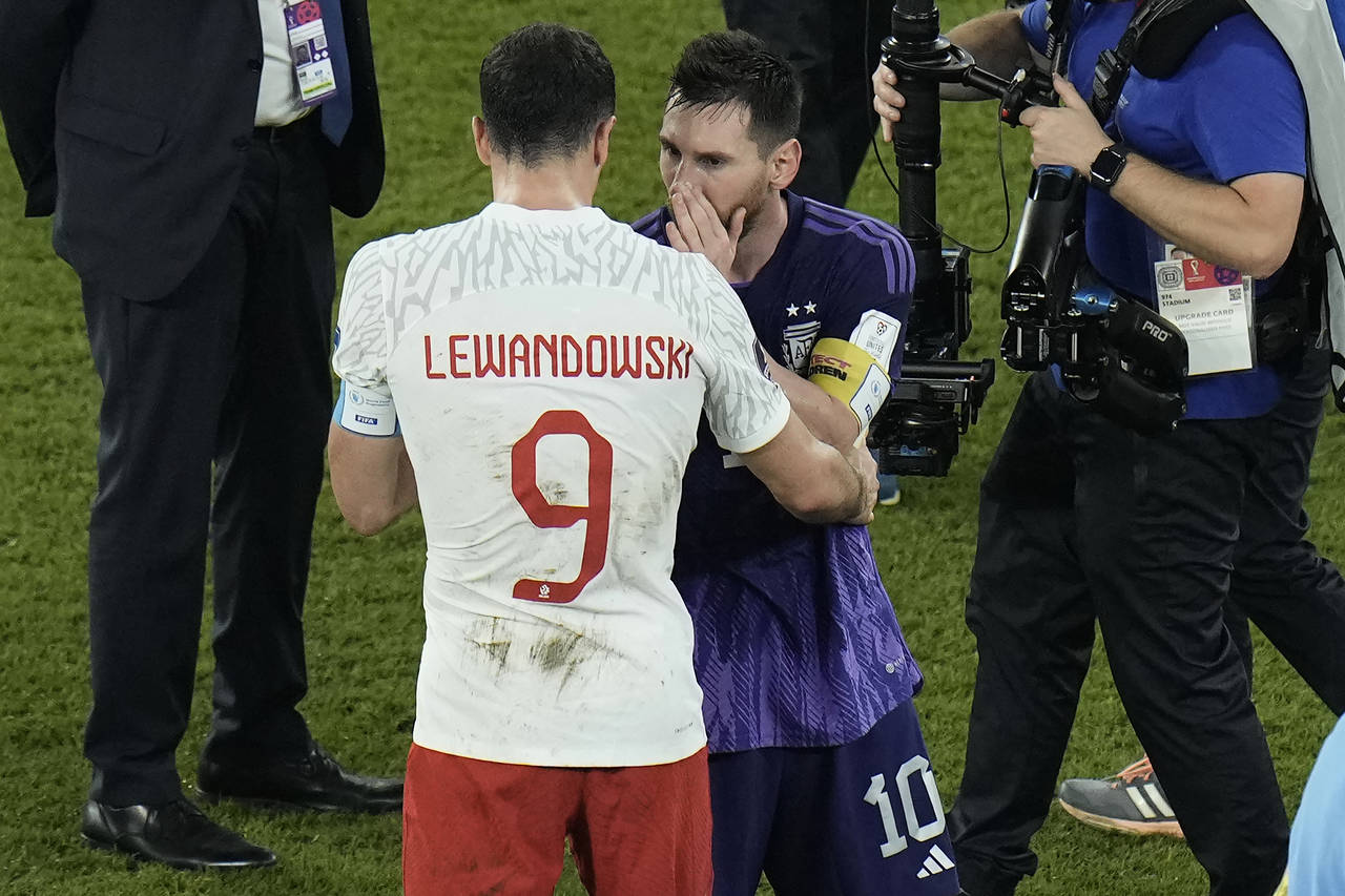 Poland's Robert Lewandowski, left, interacts with Argentina's Lionel Messi at the end of the World ...