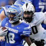 
              Memphis wide receiver Eddie Lewis (18) carries the ball as Central Florida linebacker Kam Moore, right, closes in during the second half of an NCAA college football game Saturday, Nov. 5, 2022, in Memphis, Tenn. (AP Photo/Mark Humphrey)
            