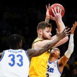 
              Michigan's Hunter Dickinson, center, protects the ball from Pittsburgh's Greg Elliott (3) and Federiko Federiko (33) during the first half of an NCAA basketball game at the Legends Classic Wednesday, Nov. 16, 2022, in New York. (AP Photo/Frank Franklin II)
            