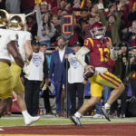 
              Southern California quarterback Caleb Williams, right, runs in for a touchdown as Notre Dame defensive lineman Chris Smith, left, and safety Justin Walters defend during the first half of an NCAA college football game Saturday, Nov. 26, 2022, in Los Angeles. (AP Photo/Mark J. Terrill)
            