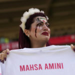 
              An Iran team supporter cries as she holds a shirt that reads 'Mahsa Amini' prior to the start of the World Cup group B soccer match between Wales and Iran, at the Ahmad Bin Ali Stadium in Al Rayyan, Qatar, Friday, Nov. 25, 2022. (AP Photo/Alessandra Tarantino)
            