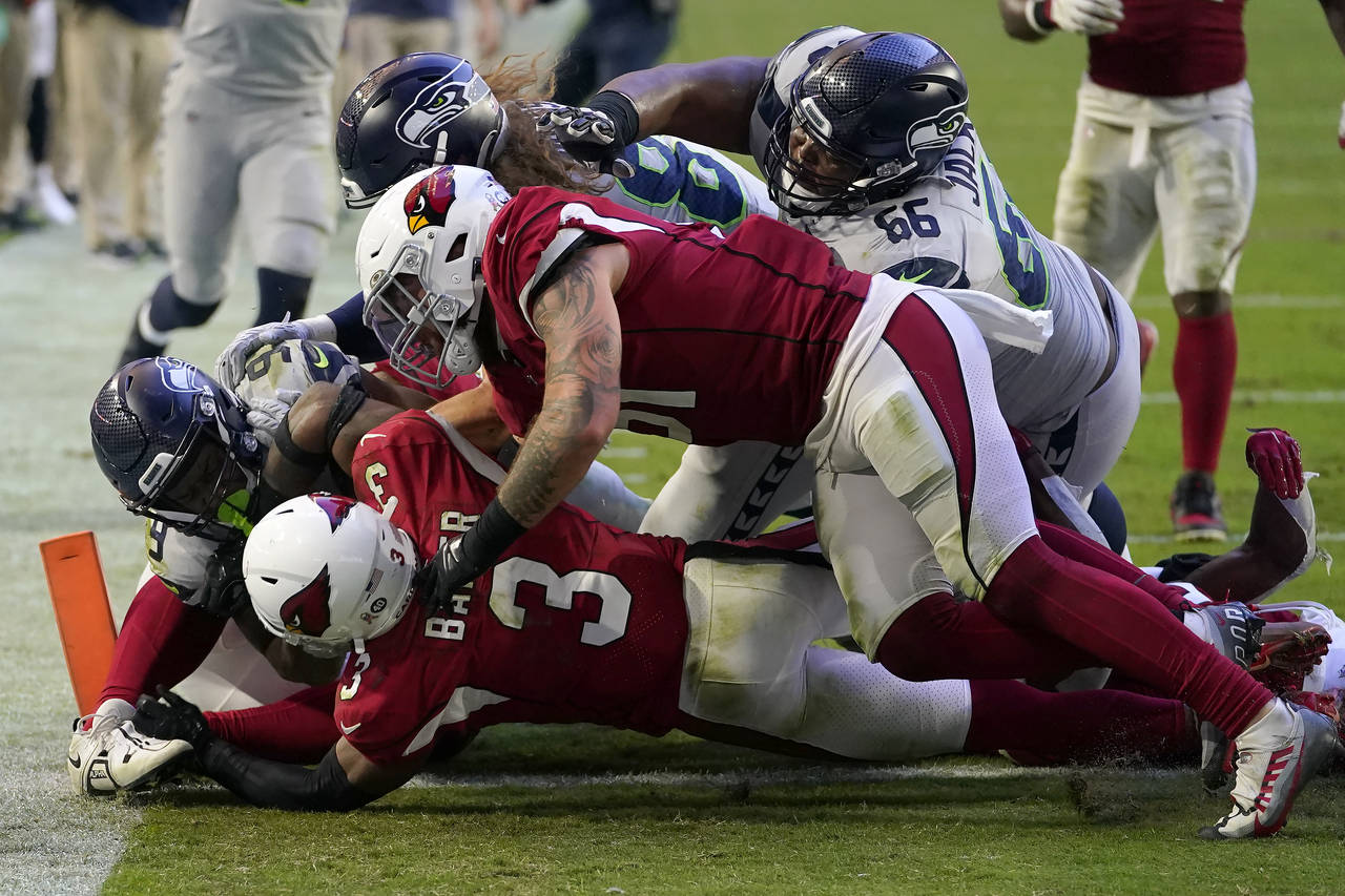 Seattle Seahawks running back Kenneth Walker III, left, scores a touchdown against the Arizona Card...