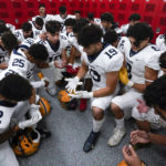 
              Crestwood High School football player Adam Berry (19) leads a muslim prayer before a game in Melvindale, Mich., Friday, Sept. 23, 2022. At Crestwood High School, where most of the football team is Muslim, the entire team gathers before practices and games to pray on one knee. (AP Photo/Paul Sancya)
            