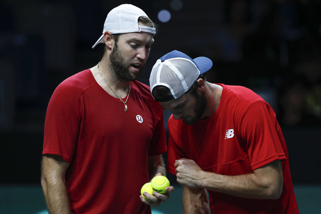 Jack Sock, left, speaks to Tommy Paul of the USA during their doubles match against Italy's Fabio F...