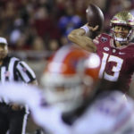 
              Florida State quarterback Jordan Travis (13) throws in the first quarter of an NCAA college football game against Florida, Friday, Nov. 25, 2022, in Tallahassee, Fla. (AP Photo/Phil Sears)
            