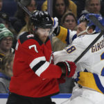 
              New Jersey Devils defenseman Dougie Hamilton (7) checks Buffalo Sabres left wing Zemgus Girgensons (28) against the glass during the first period of an NHL hockey game Friday, Nov. 25, 2022, in Buffalo, N.Y. (AP Photo/Joshua Bessex)
            