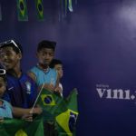 
              Students wait for Coach Tite to announce his list of players for the 2022 Soccer World Cup in Qatar, at the Paulo Freire municipal school where the player Vinicius Jr. studied, in Sao Goncalo, Rio de Janeiro state, Brazil, Monday, Nov. 7, 2022. Four years ago teenager Vinicius Jr. took his first medal from a professional soccer tournament home, a place where drug gangs and vigilantes fight for control and children dribble past garbage on the streets. Today, Vinicius is a key figure on Brazil’s World Cup team. (AP Photo/Bruna Prado)
            