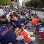 
              Luis Varela holds his 10-month-old son Joaquin as fans wait for a victory parade for the Houston Astros' World Series baseball championship Monday, Nov. 7, 2022, in Houston. (AP Photo/David Phillip)
            