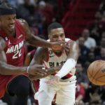 
              Miami Heat forward Jimmy Butler (22) and Portland Trail Blazers guard Damian Lillard (0) battle for a loose ball during the second half of an NBA basketball game, Monday, Nov. 7, 2022, in Miami. (AP Photo/Wilfredo Lee)
            