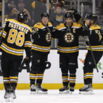 
              Boston Bruins' captain Patrice Bergeron is congratulated by Taylor Hall, right, and Charlie McAvoy after scoring against the Vancouver Canucks during the first period of an NHL hockey game Sunday, Nov. 13, 2022, in Boston. (AP Photo/Winslow Townson)
            