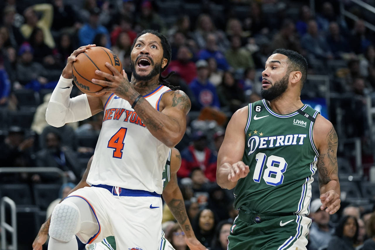 New York Knicks guard Derrick Rose (4) attempts a layup as Detroit Pistons guard Cory Joseph (18) d...