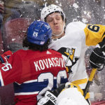 
              Montreal Canadiens' Johnathan Kovacevic (26) checks Pittsburgh Penguins' Rickard Rakell into the boards during second-period NHL hockey game action in Montreal, Saturday, Nov. 12, 2022. (Graham Hughes/The Canadian Press via AP)
            