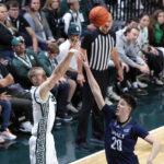 
              Michigan State's Joey Hauser, left, shoots against Northern Arizona's Nik Mains (20) during the first half of an NCAA college basketball game Monday, Nov. 7, 2022, in East Lansing, Mich. (AP Photo/Al Goldis)
            