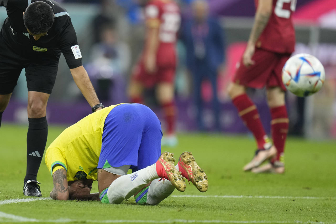 Brazil's Neymar kneels on the pitch during the World Cup group G soccer match between Brazil and Se...