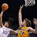 
              Kansas forward Jalen Wilson (10) short over North Dakota State forward Andrew Morgan (23) during the first half of an NCAA college basketball game Thursday, Nov. 10, 2022, in Lawrence, Kan. (AP Photo/Charlie Riedel)
            