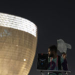 
              Osama, 21 years-old, from Palestine works as a street marshal prior to the World Cup group G soccer match between Brazil and Serbia, at the Lusail Stadium in Lusail, Qatar, Thursday, Nov. 24, 2022. The World Cup 2010 in South Africa had Shakira. The 1998 World Cup in France had Ricky Martin. In Qatar, the tune that nests itself in the head is the incessant chanting of street marshals, better knows as Last Mile Marshals. Seated all over Doha on high chairs more commonly used by lifeguards at swimming pools, these migrant workers have become a staple of the Middle East's first World Cup. (AP Photo/Moises Castillo)
            