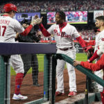 
              Philadelphia Phillies' Rhys Hoskins celebrates in the dugout after scoring after a home run during the fifth inning in Game 3 of baseball's World Series between the Houston Astros and the Philadelphia Phillies on Tuesday, Nov. 1, 2022, in Philadelphia. (AP Photo/David J. Phillip)
            