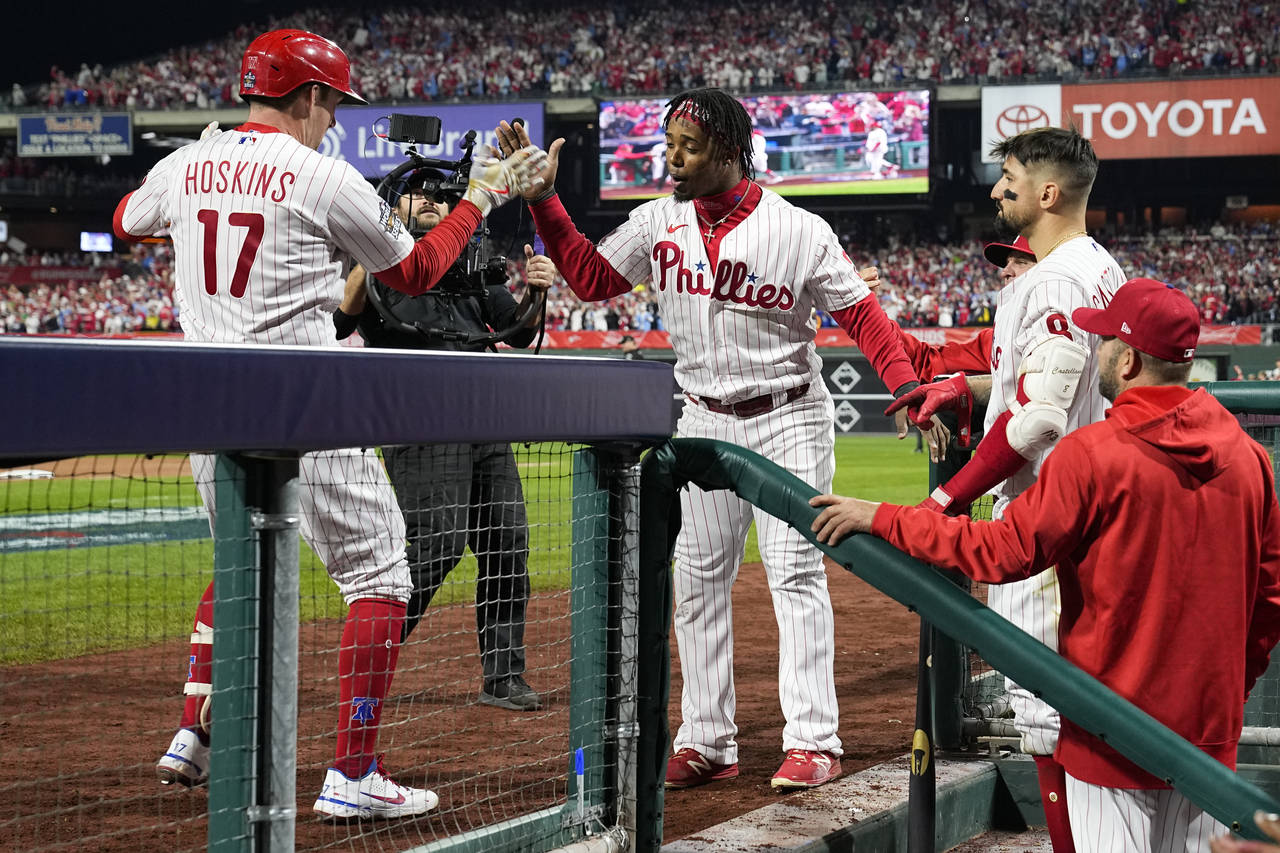 Philadelphia Phillies' Rhys Hoskins celebrates in the dugout after scoring after a home run during ...