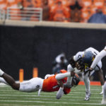 
              Oklahoma State linebacker Xavier Benson tackles West Virginia running back Tony Mathis Jr. (24) in the first half of the NCAA college football game in Stillwater, Okla., Saturday Nov. 26, 2022. (AP Photo/Mitch Alcala)
            