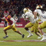 
              Southern California quarterback Caleb Williams, left, is chase by members of Notre Dame during the first half of an NCAA college football game Saturday, Nov. 26, 2022, in Los Angeles. (AP Photo/Mark J. Terrill)
            