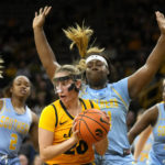 
              Iowa guard Kate Martin (20) grabs a rebound in front of Southern forward Raven White (44) during the first half of an NCAA college basketball game, Monday, Nov. 7, 2022, in Iowa City, Iowa. (AP Photo/Charlie Neibergall)
            
