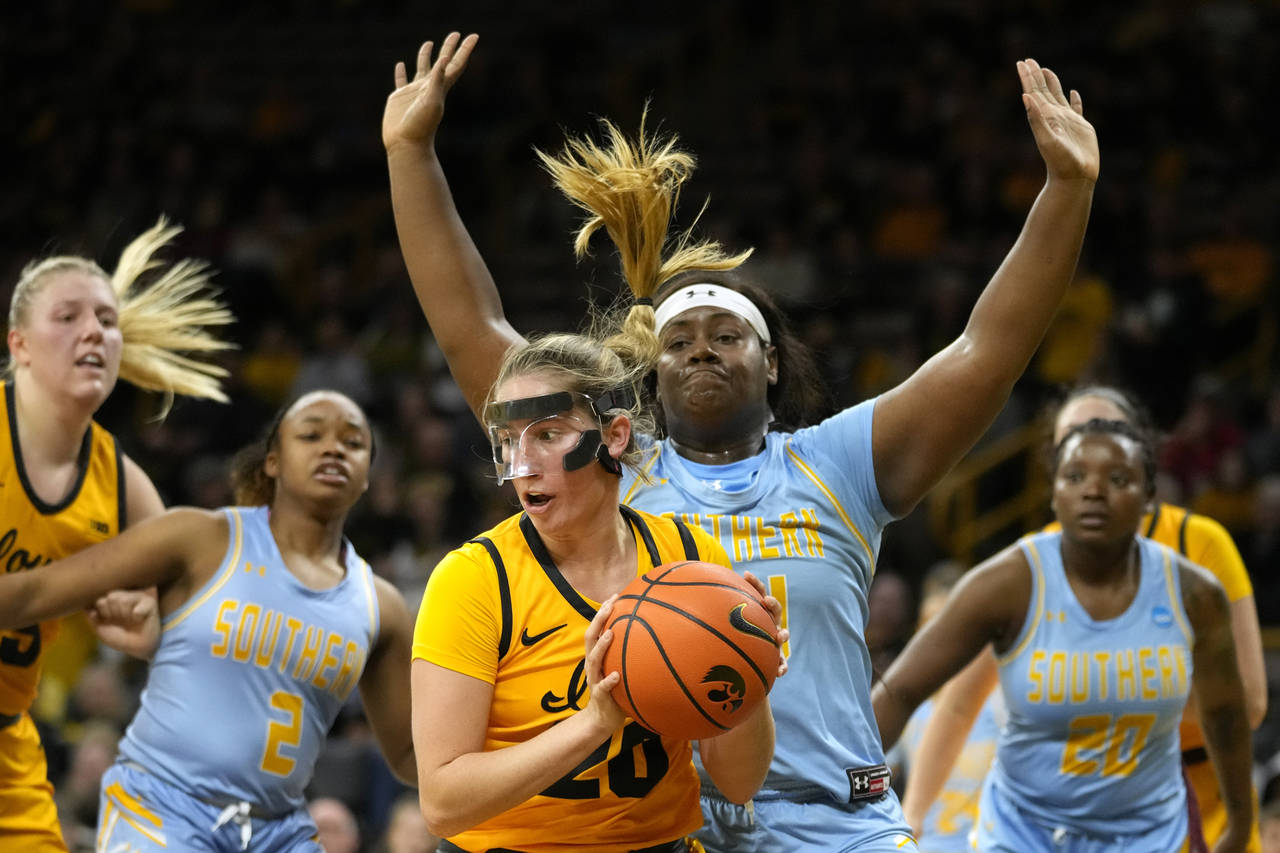 Iowa guard Kate Martin (20) grabs a rebound in front of Southern forward Raven White (44) during th...
