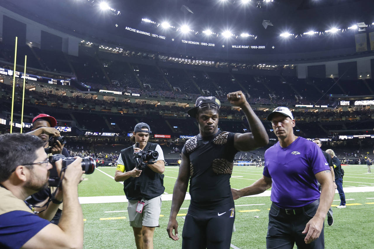 Baltimore Ravens quarterback Lamar Jackson, center, celebrates after an NFL football game against t...