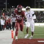 
              Washington State running back Nakia Watson (25) runs for a touchdown while defended by Washington cornerback Jordan Perryman (1) during the first half of an NCAA college football game, Saturday, Nov. 26, 2022, in Pullman, Wash. (AP Photo/Young Kwak)
            