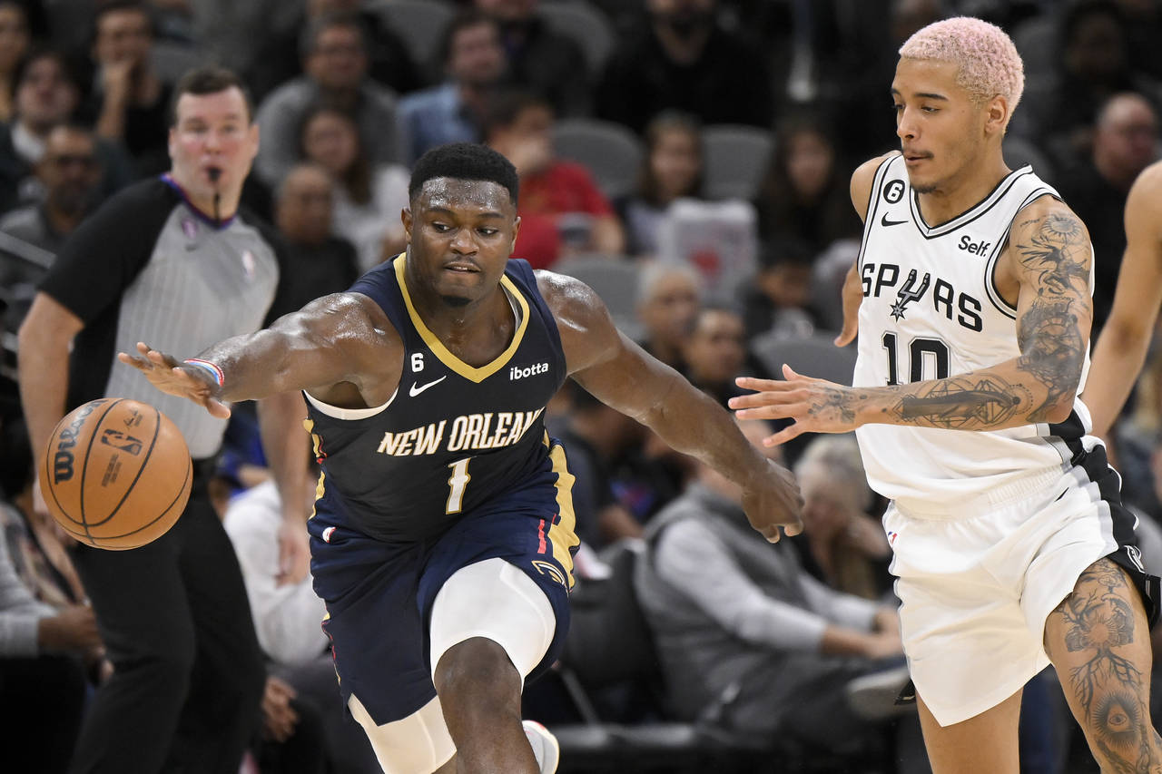 New Orleans Pelicans' Zion Williamson (1) and San Antonio Spurs' Jeremy Sochan chase the ball durin...
