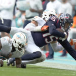 
              Miami Dolphins linebacker Jaelan Phillips (15) tackles Houston Texans wide receiver Chris Moore (15) during the second half of an NFL football game, Sunday, Nov. 27, 2022, in Miami Gardens, Fla. (AP Photo/Lynne Sladky)
            