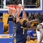 
              West Virginia's Emmitt Matthews Jr. (1) goes in for a dunk past Pittsburgh's Federiko Federiko during the first half of an NCAA college basketball game, Friday, Nov. 11, 2022, in Pittsburgh. (AP Photo/Keith Srakocic)
            