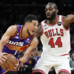 
              Phoenix Suns guard Devin Booker, left, drives past Chicago Bulls forward Patrick Williams (44) during the first half of an NBA basketball game in Phoenix, Wednesday, Nov. 30, 2022. (AP Photo/Ross D. Franklin)
            