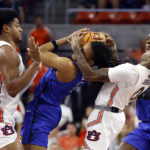 
              Saint Louis guard Yuri Collins, center, battles for the ball with Auburn center Dylan Cardwell, left, and guard K.D. Johnson during the first half of an NCAA college basketball game Sunday, Nov. 27, 2022, in Auburn, Ala. (AP Photo/Butch Dill)
            