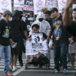 
              A protester sits on a wheelchair representing depicting the victims of Oct. 1 soccer stampede, during a rally commemorating 40 days since the tragedy, in Malang, East Java, Indonesia, Thursday, Nov. 10, 2022. Thousands of people rallied Thursday demanding justice and a thorough investigation into those they blame for the stampede at Kanjuruhan soccer stadium that left a number of people dead after police fired tear gas at a domestic league soccer match and caused a deadly crush as spectators attempted to flee. (AP Photo/Rizki Dwi Putra)
            