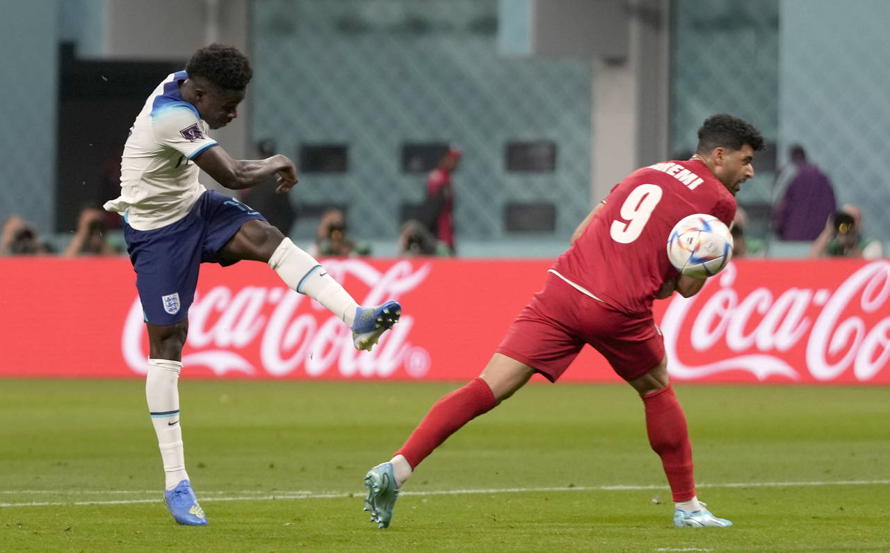 England's Bukayo Saka, left, scores his side's second goal during the World Cup group B soccer matc...
