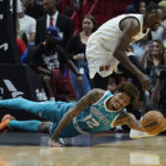 
              Charlotte Hornets guard Kelly Oubre Jr. (12) and Miami Heat center Bam Adebayo (13) go after a loose ball during the first half of an NBA basketball game Saturday, Nov. 12, 2022, in Miami. (AP Photo/Marta Lavandier)
            