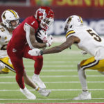 
              Fresno State wide receiver Nikko Remigio tries to get by Wyoming defensive back Wrook Brown, left, and cornerback Deron Harrell during the first half of an NCAA college football game in Fresno, Calif., Friday, Nov. 25, 2022. (AP Photo/Gary Kazanjian)
            