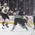 
              Vegas Golden Knights' Paul Cotter, left, jumps to avoid a hit by Vancouver Canucks' Luke Schenn (2) during the second period of an NHL hockey game in Vancouver, British Columbia, Monday, Nov. 21, 2022. (Darryl Dyck/The Canadian Press via AP)
            