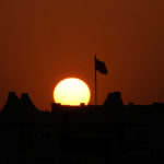 
              A flag waves over a house as the sun sets in Al-Ruwais, Qatar, Friday, Nov. 25, 2022. (AP Photo/Matthias Schrader)
            