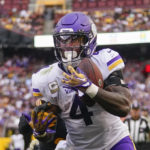 
              Minnesota Vikings running back Dalvin Cook (4) makes a touchdown catch against Washington Commanders safety Kamren Curl (31) during the second half of an NFL football game, Sunday, Nov. 6, 2022, in Landover, Md. (AP Photo/Julio Cortez)
            