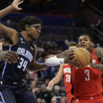 
              Houston Rockets guard Kevin Porter Jr. (3) is defended by Orlando Magic center Wendell Carter Jr. (34) during the first half of an NBA basketball game, Monday, Nov. 7, 2022, in Orlando, Fla. (AP Photo/Kevin Kolczynski)
            