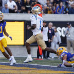 
              UCLA quarterback Dorian Thompson-Robinson (1) runs for a touchdown against California cornerback Tyson McWilliams (11) and safety Daniel Scott, right, during the second half of an NCAA college football game in Berkeley, Calif., Friday, Nov. 25, 2022. (AP Photo/Jed Jacobsohn)
            