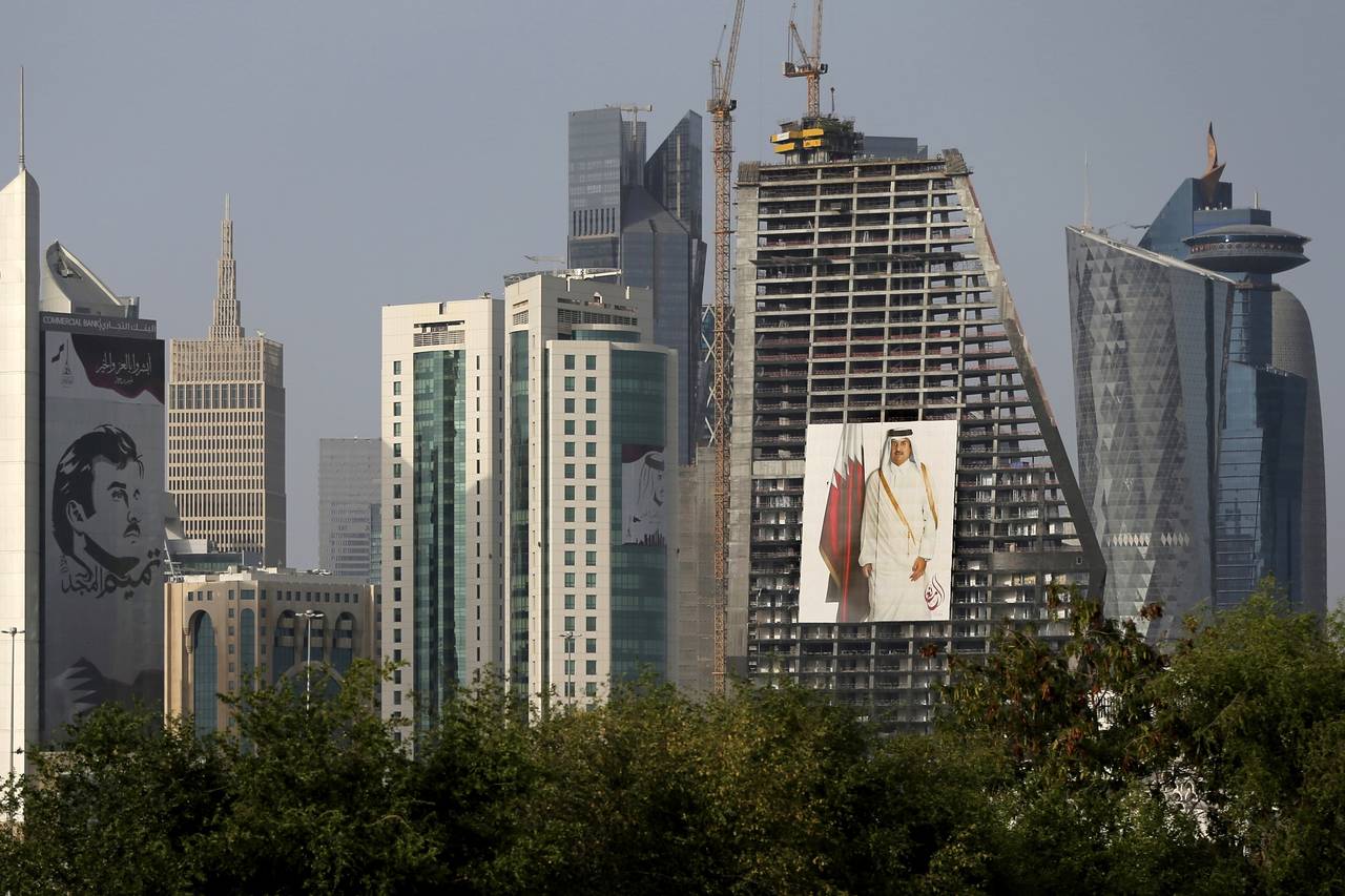 FILE - The images of the Emir of Qatar, Sheikh Tamim bin Hamad Al Thani hang on the towers in Doha,...