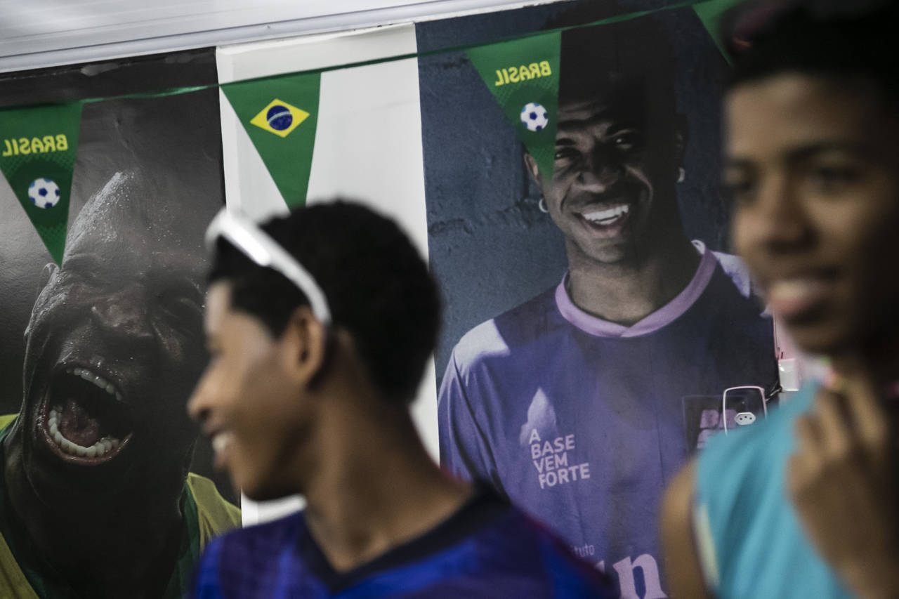 Photos of Vinicius Jr. cover the wall where students wait for coach Tite to announce his list of pl...