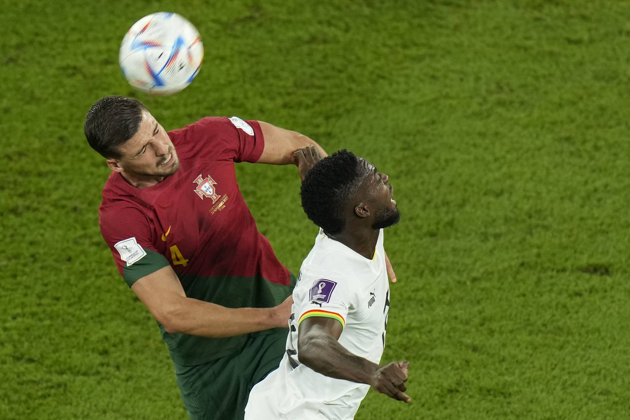 Portugal's Ruben Dias, left, and Ghana's Inaki Williams challenge for the ball during the World Cup...