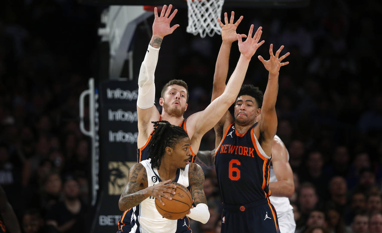 Memphis Grizzlies guard Ja Morant, with the ball, is defended by New York Knicks center Isaiah Hart...
