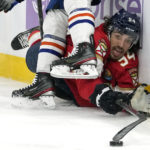 
              Florida Panthers left wing Ryan Lomberg (94) falls to the ice as he collides with Edmonton Oilers defenseman Tyson Barrie during the second period of an NHL hockey game, Saturday, Nov. 12, 2022, in Sunrise, Fla. (AP Photo/Lynne Sladky)
            