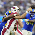 
              Arizona Cardinals quarterback Colt McCoy is hit by Los Angeles Rams linebacker Justin Hollins as he throws during the second half of an NFL football game Sunday, Nov. 13, 2022, in Inglewood, Calif. (AP Photo/Jae C. Hong)
            