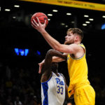 
              Michigan's Hunter Dickinson, right, drives past Pittsburgh's Federiko Federiko during the first half of an NCAA basketball game at the Legends Classic Wednesday, Nov. 16, 2022, in New York. (AP Photo/Frank Franklin II)
            