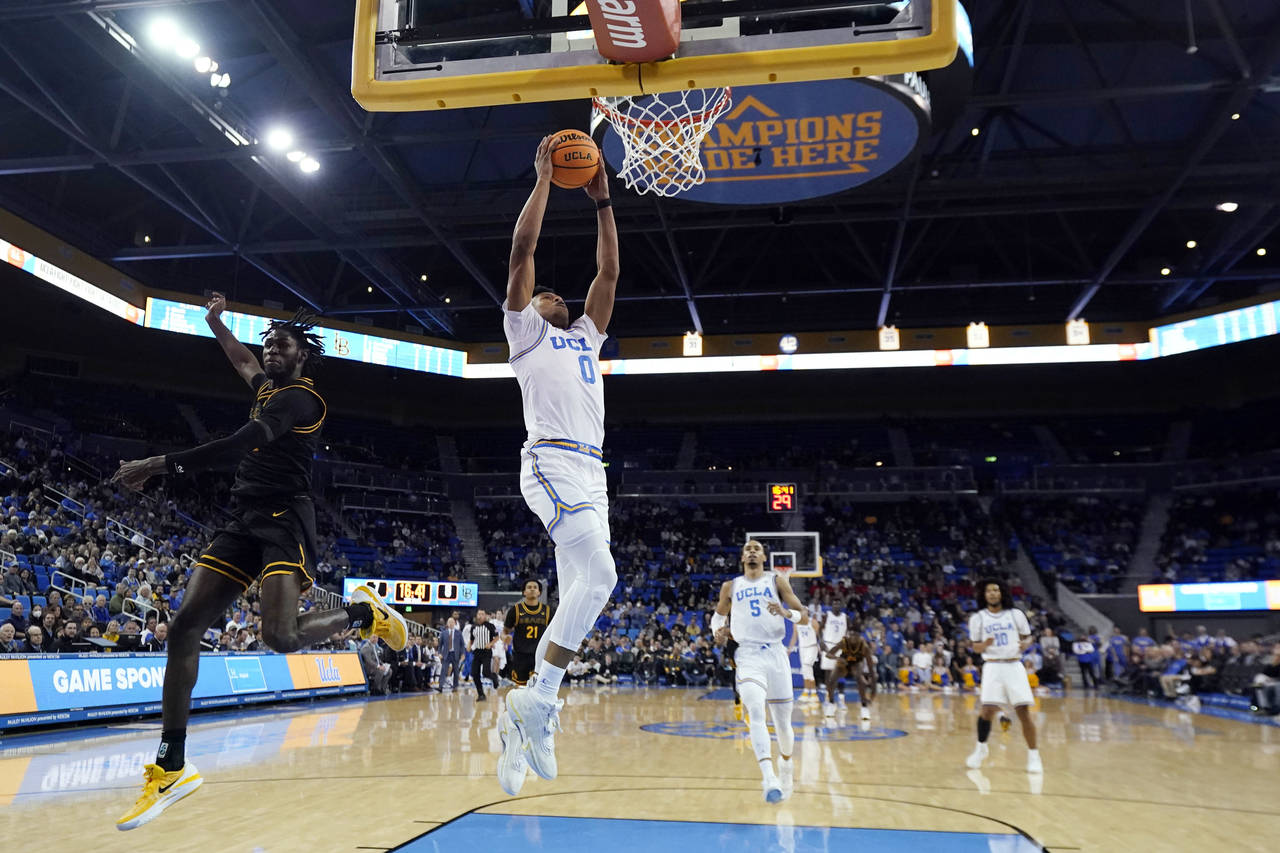 UCLA guard Jaylen Clark (0) dunks past Long Beach State guard Jadon Jones, left, during the first h...